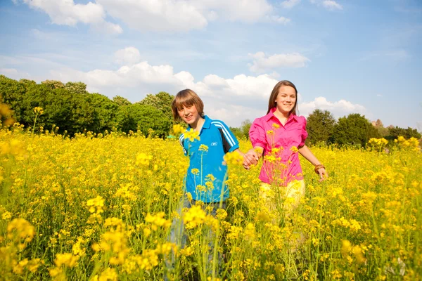 女孩和男孩放松在草甸充满了黄色的花朵 软焦点 把重点放在眼睛上 — 图库照片