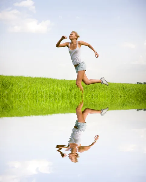 Gelukkig jonge vrouwen runing in veld — Stockfoto
