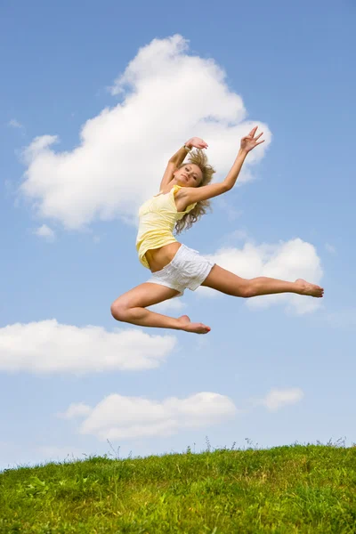 Menina feliz pulando no prado verde — Fotografia de Stock