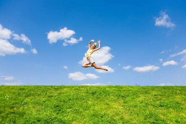 Glückliche junge Frau tanzt auf einem Feld — Stockfoto