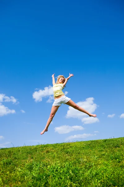 幸せな若い女性は フィールドにジャンプします — ストック写真