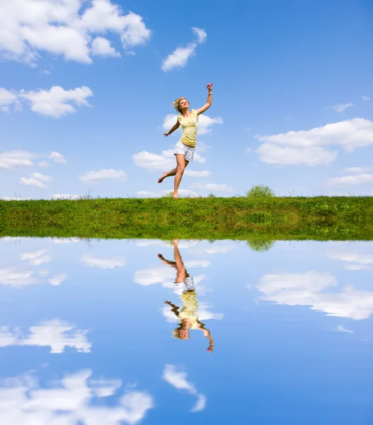 Happy young woman is running in a field — Stock Photo, Image