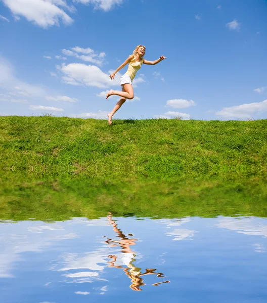 Giovane donna felice sta correndo in un campo — Foto Stock