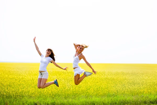 Two Beautiful Girl White Clothes Jumps Yellow Flowers — Stock Photo, Image