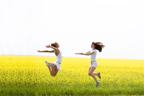 白い服を着て つの美しい少女ジャンプ黄色の花 — ストック写真