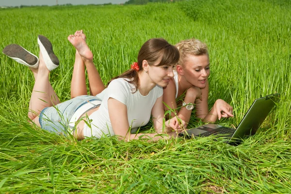 Дві Красиві Дівчата Білому Одязі Сміються Дивляться Ноутбук Відкритому Повітрі — стокове фото