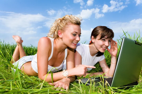 Two beautiful girls in white clothes are laughing and looking at — Stock Photo, Image