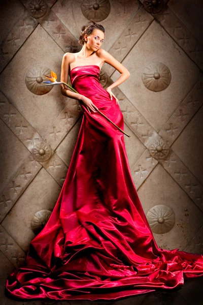 Mooi Meisje Lange Rode Jurk Houdt Exotische Bloem Hand — Stockfoto