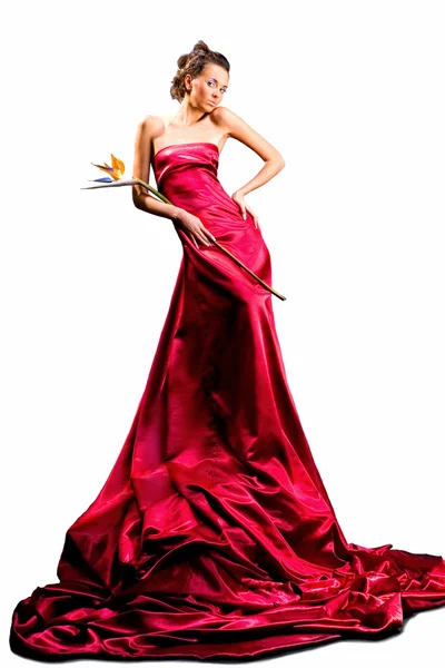 長い赤いドレスで美しい少女を手でエキゾチックな花を保持します — ストック写真