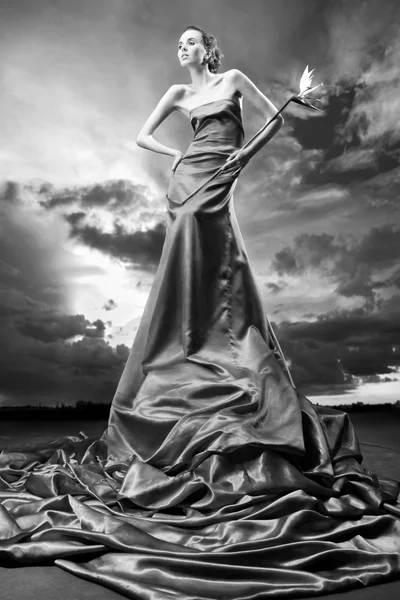 Красивая Девушка Длинном Платье Держит Руке Экзотический Цветок Фоне Облачного — стоковое фото