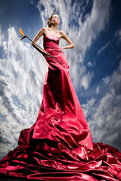 Uzun Kırmızı Elbiseli Güzel Kız Egzotik Çiçek Elinde Tutan — Stok fotoğraf