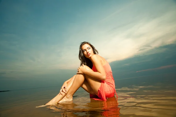 Beautiful girl sitting on water — Stock Photo, Image