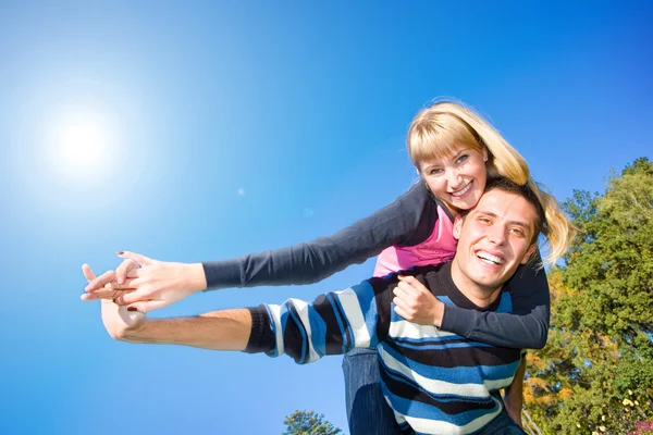 年轻的爱夫妇微笑结束下蓝蓝的天空飞 — 图库照片