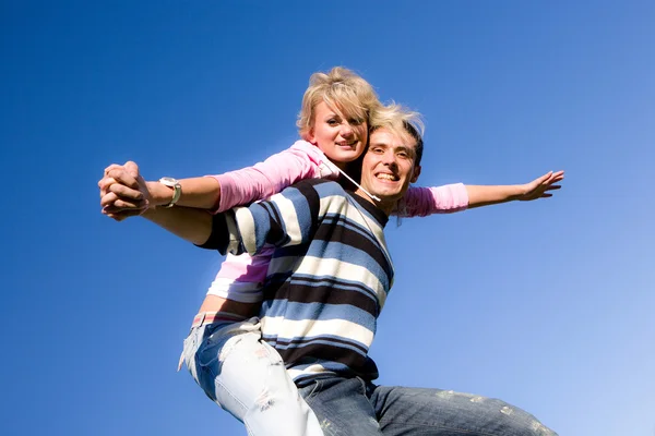 Para młoda miłość uśmiechający się pod błękitne niebo — Zdjęcie stockowe