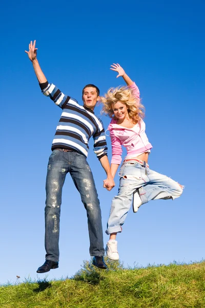 Feliz Joven Pareja Saltando Cielo Sobre Prado Verde —  Fotos de Stock