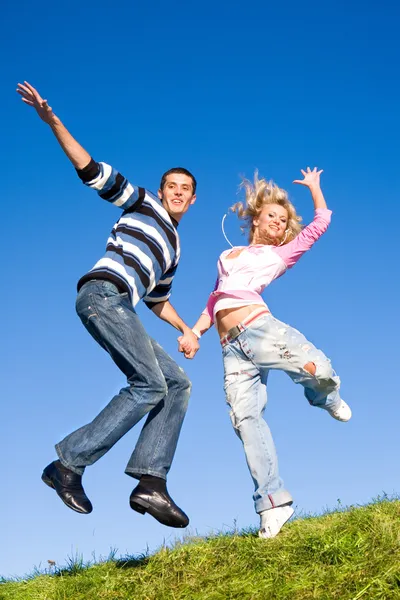 Gelukkige Jonge Paar Springen Hemel Boven Een Groene Weide — Stockfoto