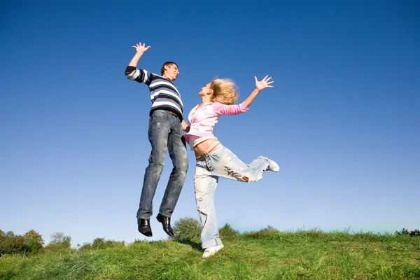 Gelukkige Jonge Paar Springen Hemel Boven Een Groene Weide — Stockfoto