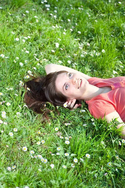 Jeune femme souriante dans l'herbe verte — Photo