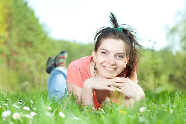 Χαμογελώντας νεαρή γυναίκα στο πράσινο γρασίδι — Φωτογραφία Αρχείου