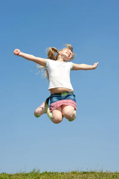Kleines Mädchen springt gegen den schönen Himmel — Stockfoto