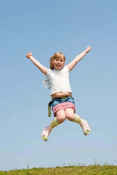 Menina saltando contra o céu bonito — Fotografia de Stock
