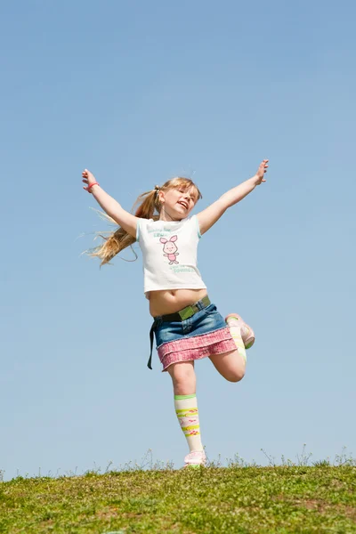 Little girl jumping against beautiful sky — Stock Photo, Image