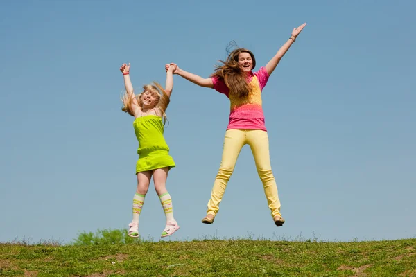 Twee Meisjes Springen Groene Weide — Stockfoto