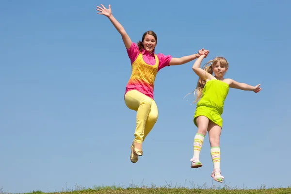 Dos Chicas Saltando Prado Verde —  Fotos de Stock