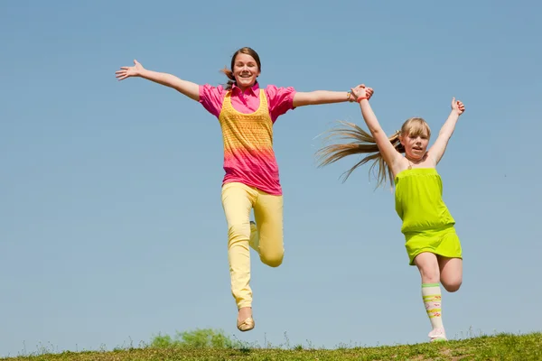 Two Girls Jumping Green Meadow — Stock Photo, Image