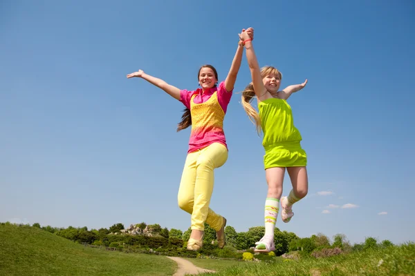 Zwei Mädchen Springen Auf Grüne Wiese — Stockfoto