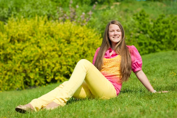 Chica bastante sonriente manos abiertas relajarse en el prado verde. Suave fo — Foto de Stock
