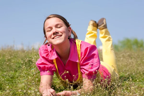 Menina muito sorridente relaxante no prado verde cheio de flores. Então... — Fotografia de Stock