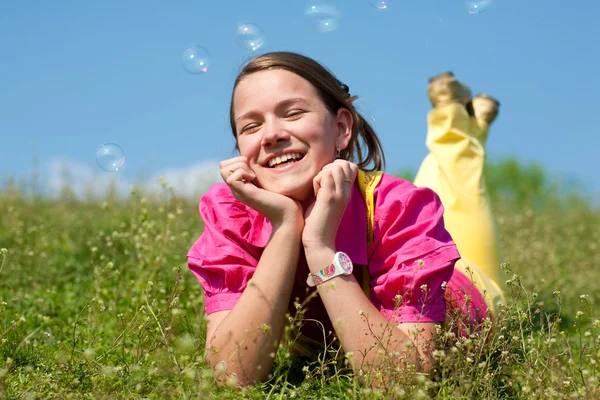 Bardzo uśmiechnięte dziewczyny na zielony łąka pełna kwiatów. tak — Zdjęcie stockowe