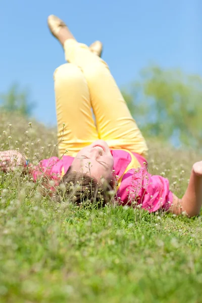Chica bastante sonriente relajándose en el prado verde lleno de flores. Así que... —  Fotos de Stock
