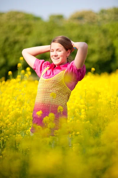 かなり微笑の女の子は花でいっぱいの緑の牧草地でリラックス ソフト フォーカス 目に焦点を当てる — ストック写真
