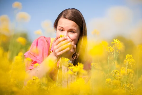 Ganska leende flicka avkopplande på äng full av gula blommor. s — Stockfoto