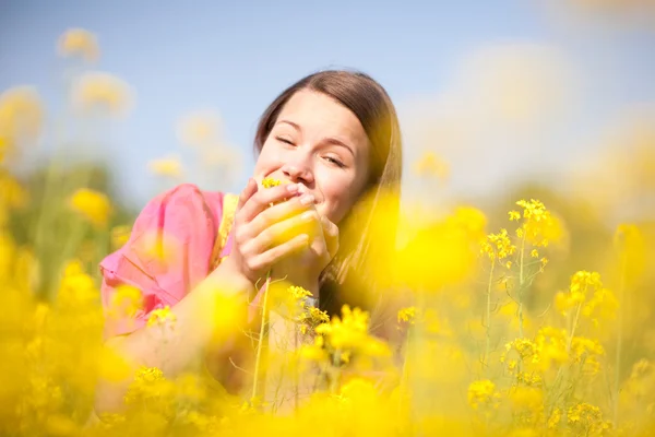 Szép mosolygó lány pihentető, zöld réten virágokkal teli. így — Stock Fotó