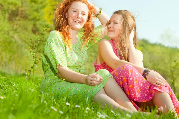 Divertida madre e hija sentado en la hierba verde — Foto de Stock