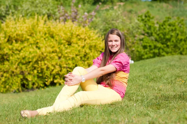 Chica bastante sonriente relajándose en el prado verde. Foco suave. Enfoque — Foto de Stock