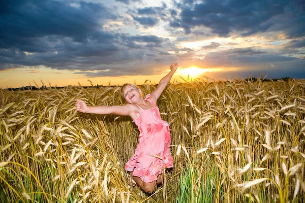 Klein Meisje Springt Een Tarweveld Tegen Achtergrond Van Wolkenluchten — Stockfoto