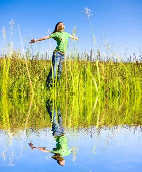 Glad ung kvinna njuter av sommaren. mot bakgrund av blå — Stockfoto