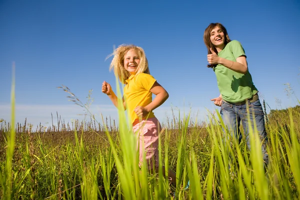 Felice donna e ragazza facendo esercizi sul campo — Foto Stock