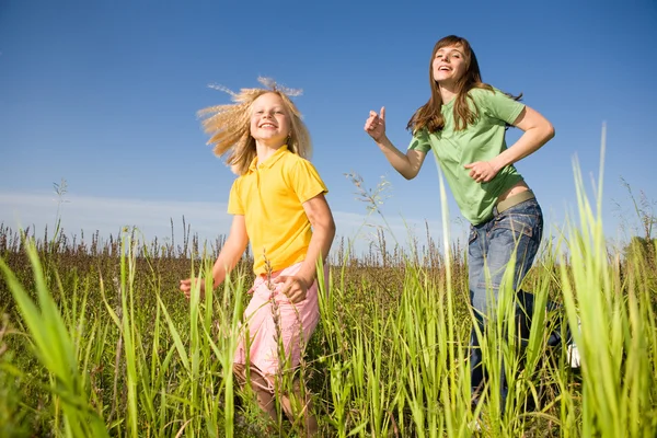 Mujer feliz y chica haciendo ejercicios en el campo —  Fotos de Stock