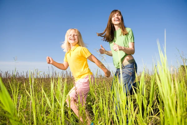 Femme heureuse et fille faisant des exercices sur le terrain — Photo