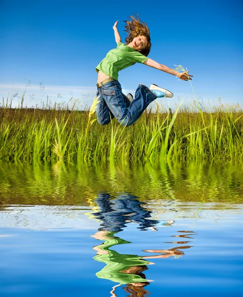 Heureuse jeune femme saute dans un champ — Photo