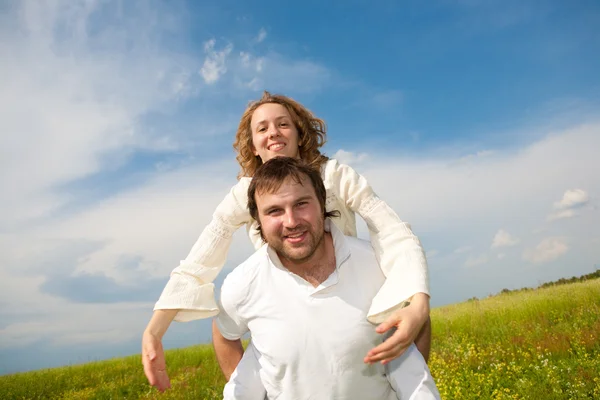 年轻的爱夫妇微笑在蓝蓝的天空下 免版税图库照片
