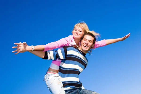 Happy young couple jumping in sky above a green meadow Stock Photo
