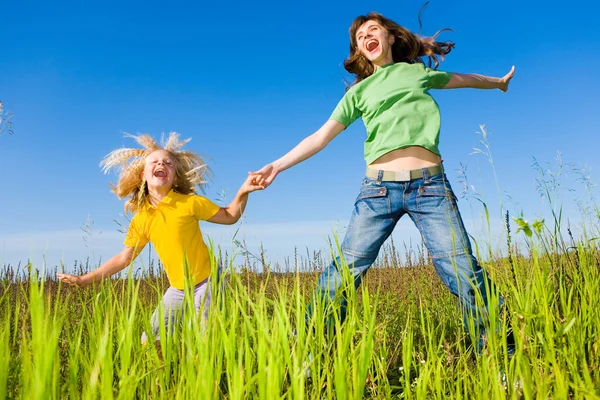 Happy woman and girl making exercises on field. — Stock Photo, Image