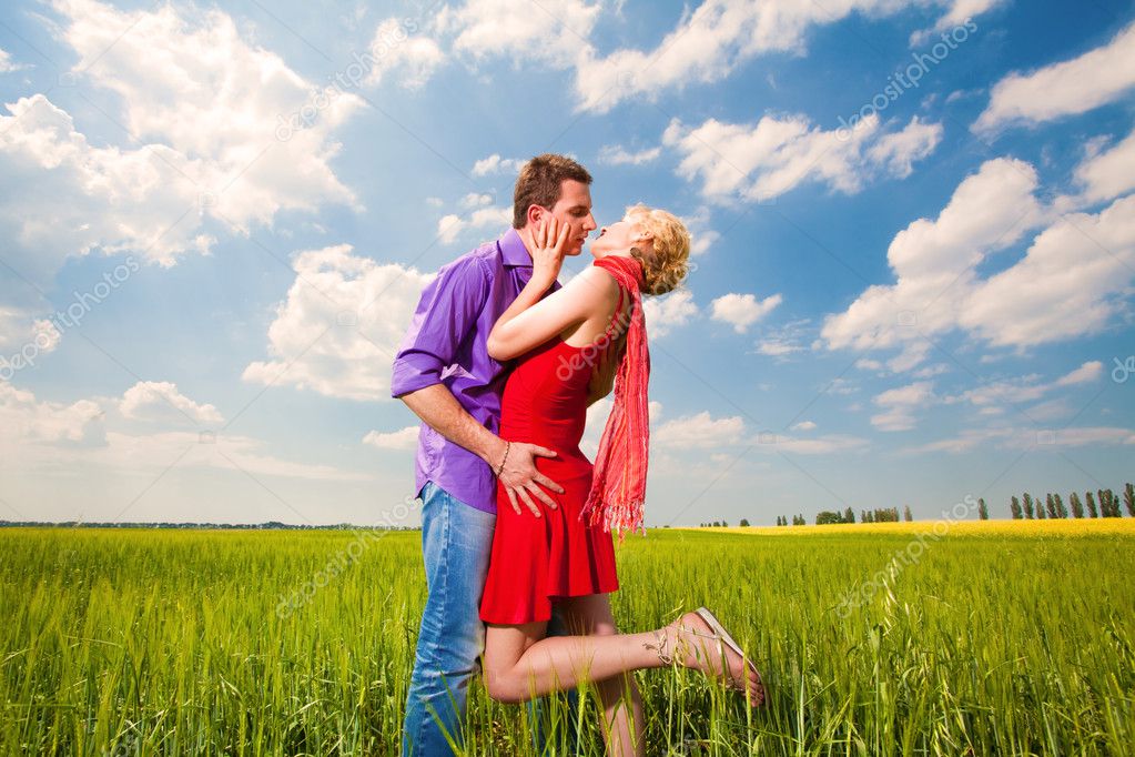 Young love Couple kissing under blue sky — Stock Photo © edfoto 4710650