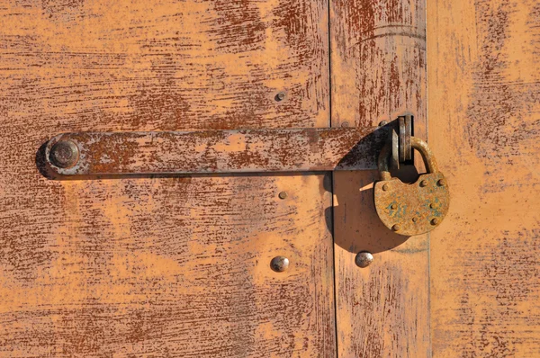 Old rusty padlock with metal bar — Stock Photo, Image